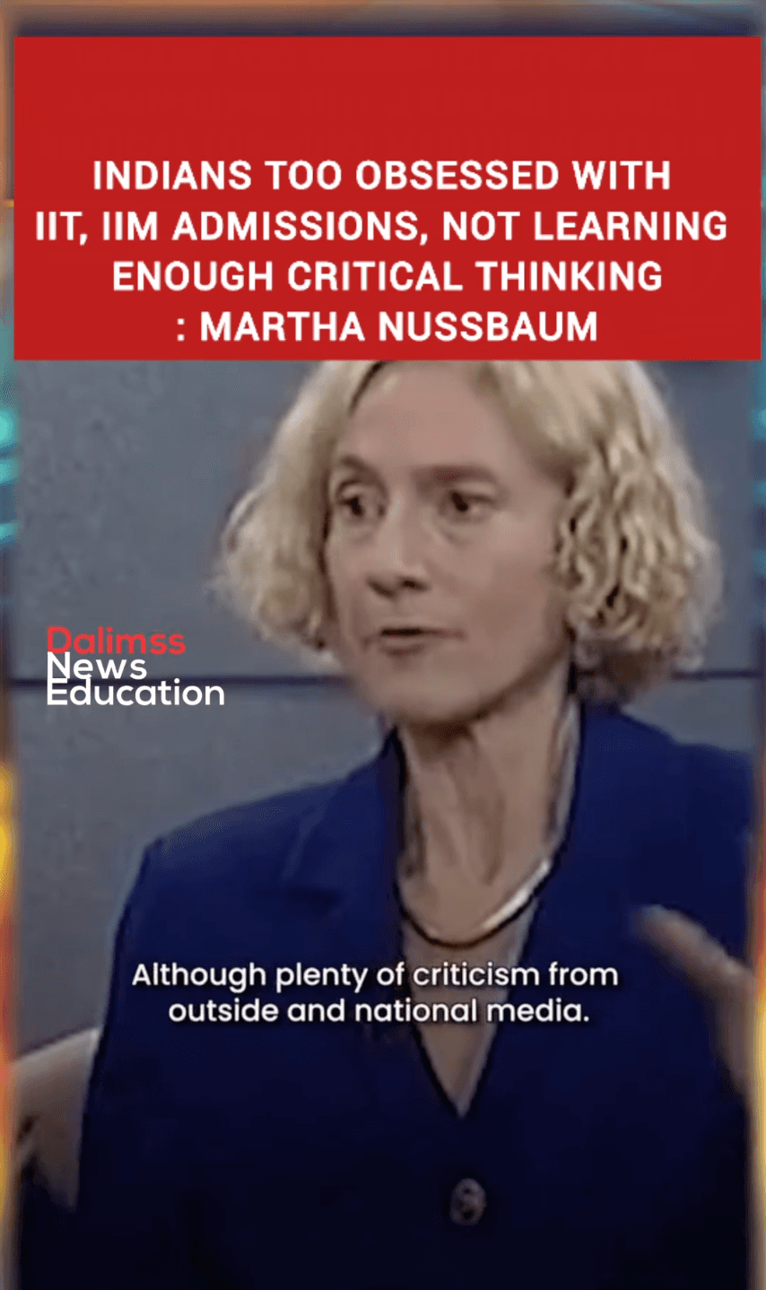 A woman with curly fair hair in a blue jacket speaks in a studio, below a red headline banner.
