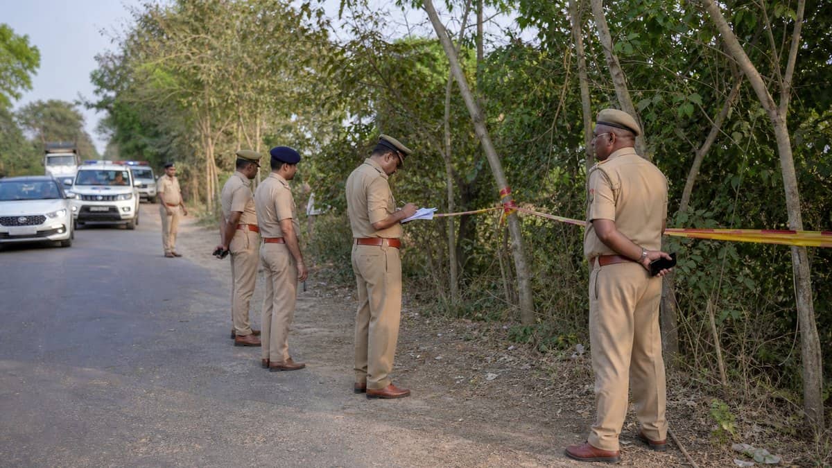 Police officers inspecting a rural roadside area during a sensitive crime investigation in Jaunpur