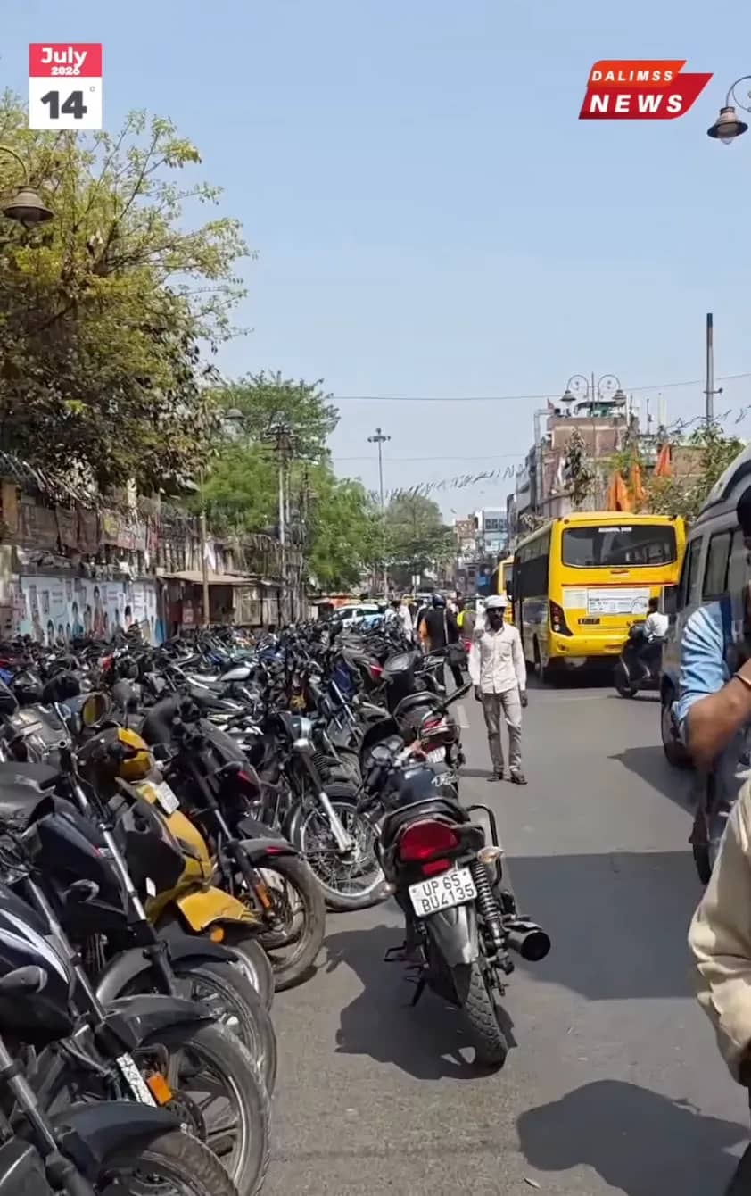 An authorized municipal towing crane lifting an illegally parked scooter from a designated no parking zone on a busy road in Varanasi
