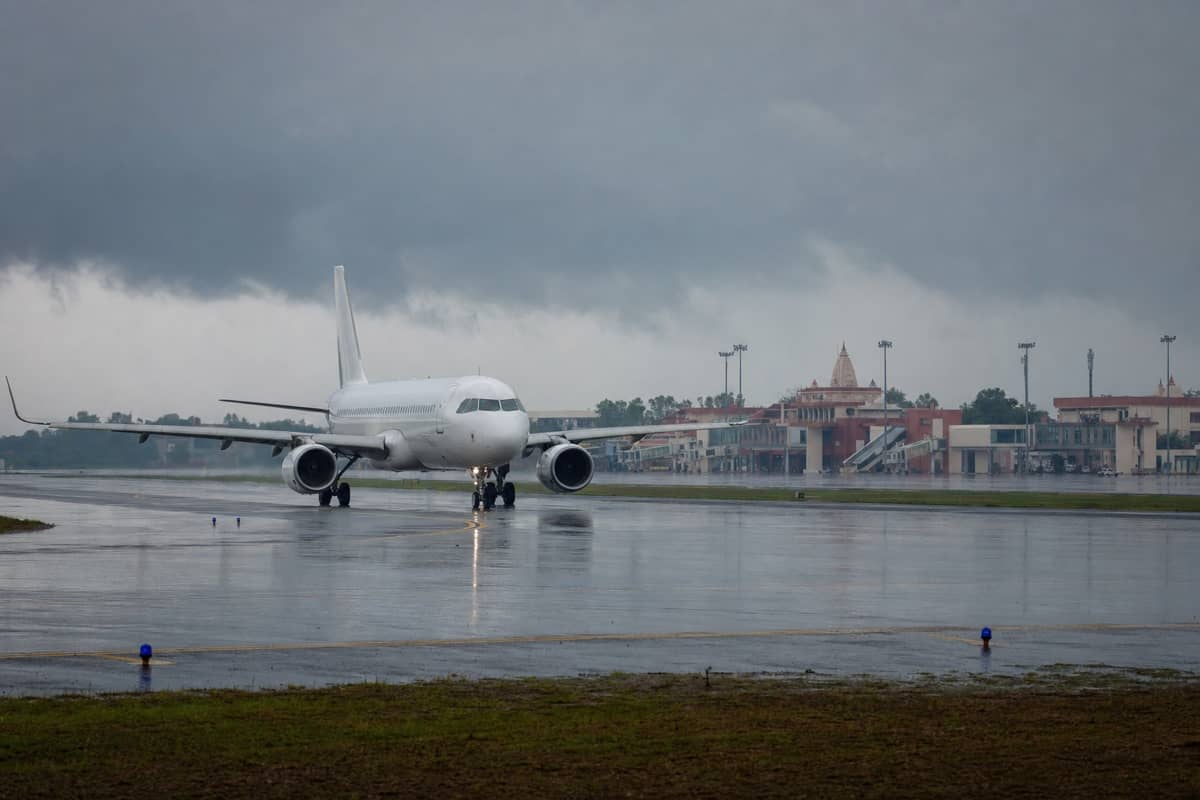 Passenger aircraft on a wet runway at Varanasi airport under monsoon clouds