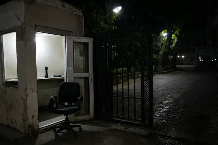 An empty security chair at a gated Gurugram property at night