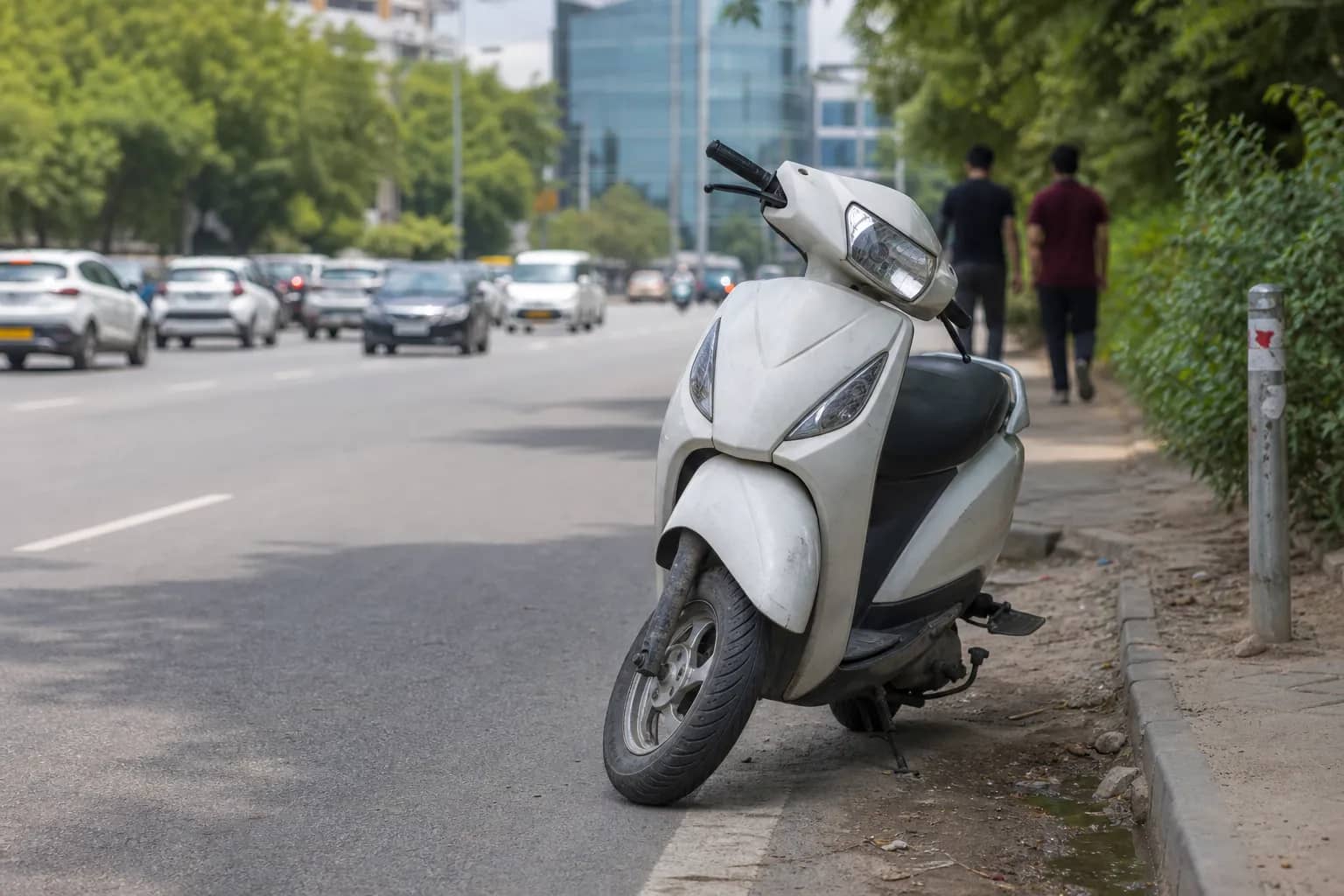 Scooter stopped beside a Gurugram road after a suspected staged collision