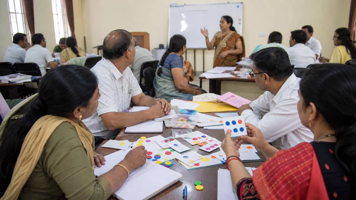 Primary-school teachers using maths counters during a training workshop