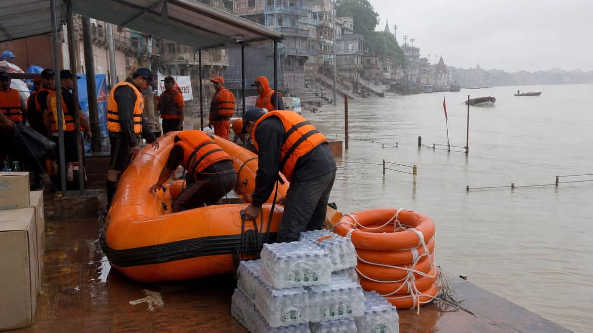 Rescue teams checking boats and relief supplies beside the rising Ganga