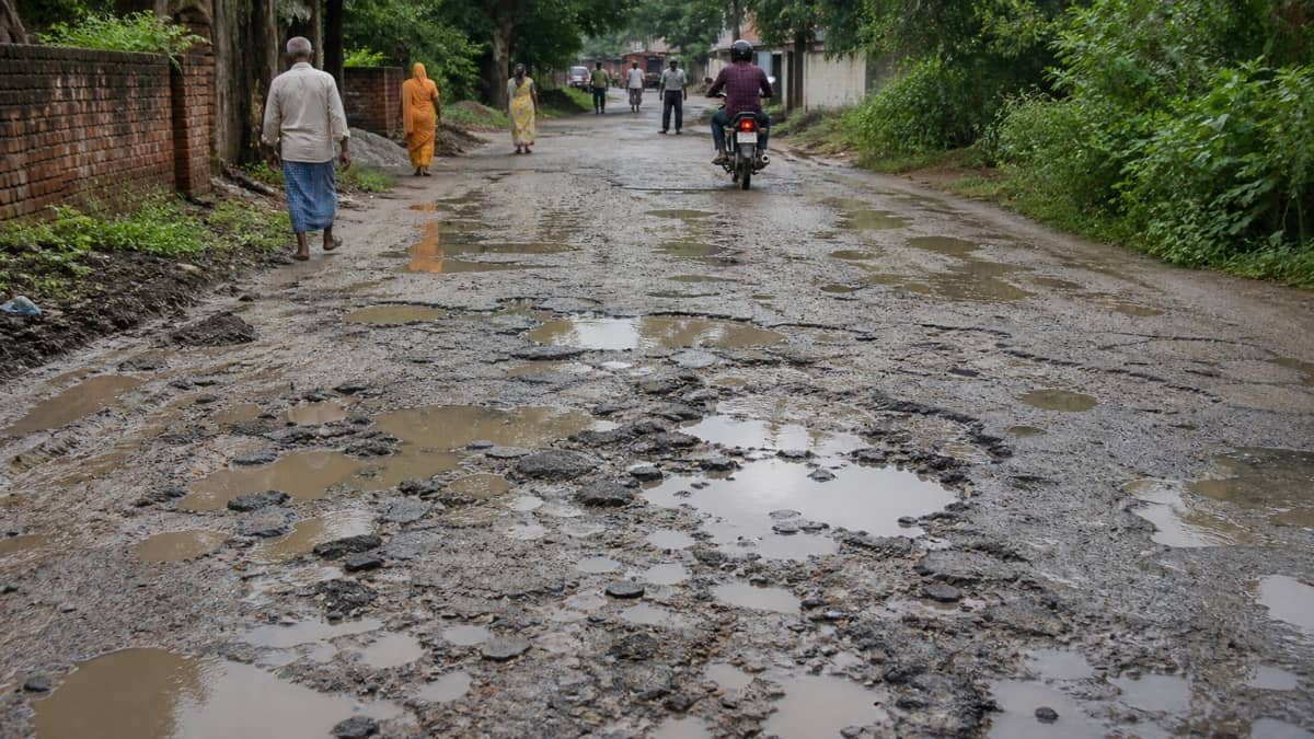 Broken asphalt, puddles and mud on a village road near Varanasi