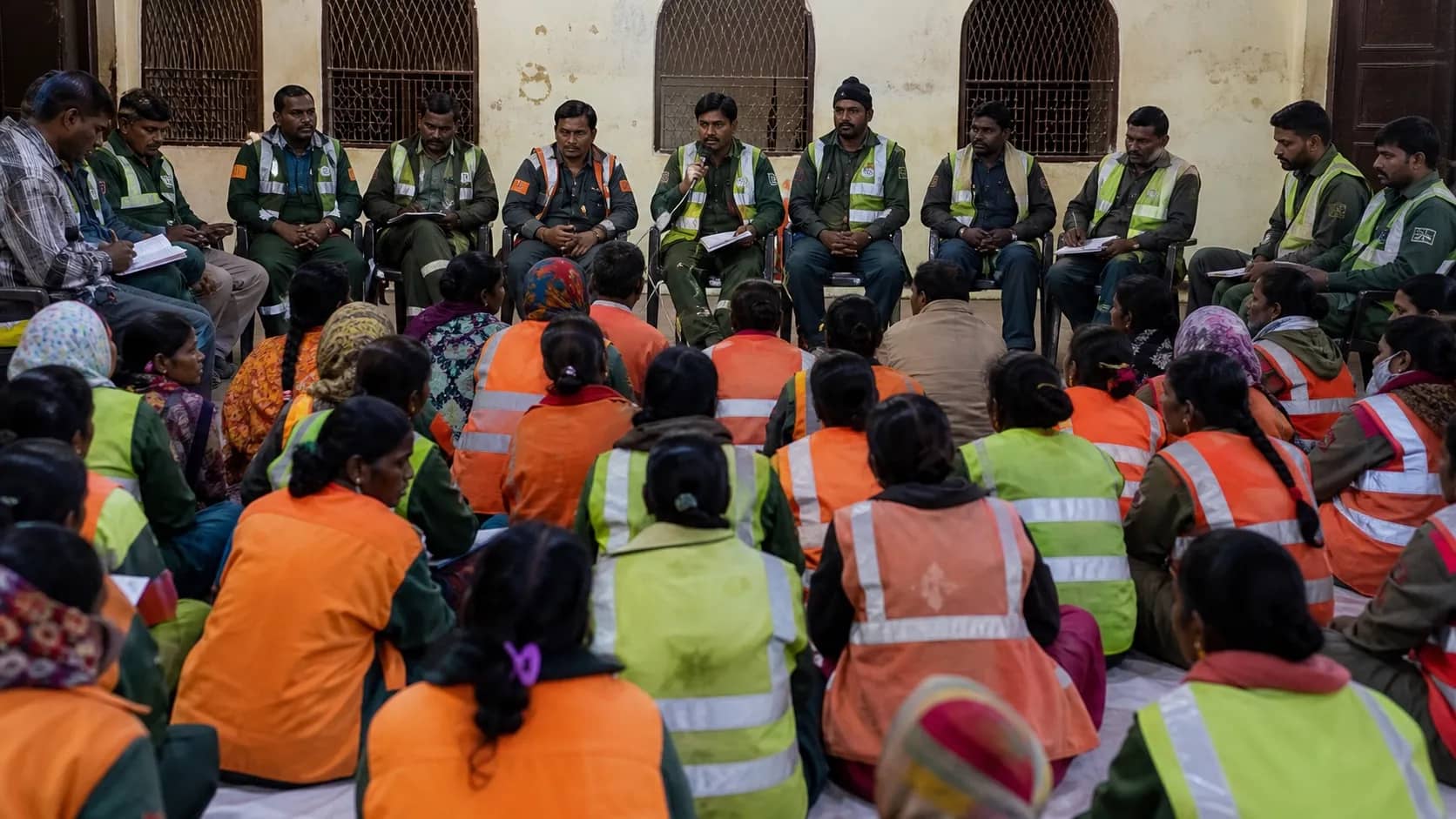 Municipal sanitation workers meeting in a community hall in Varanasi after their shift