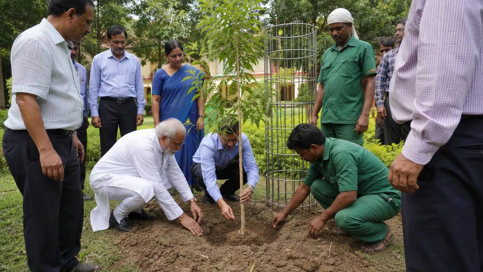 University staff planting a white sandalwood sapling in the Malaviya Bhavan grounds at BHU