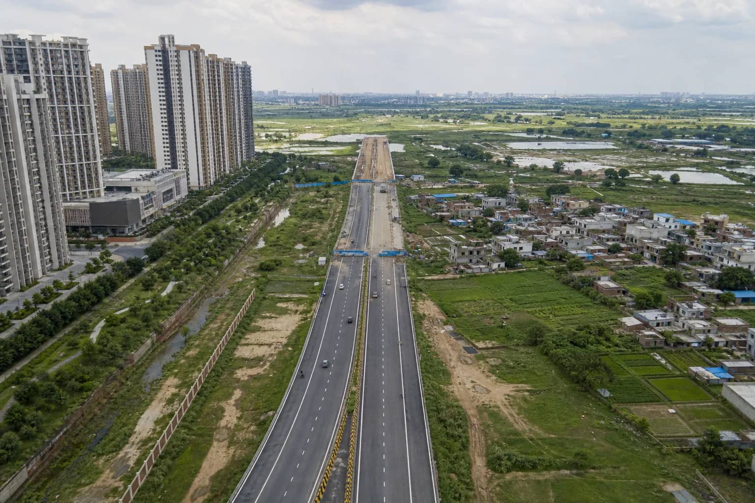 Wide Gurugram sector road approaching the Delhi border near Dwarka Expressway