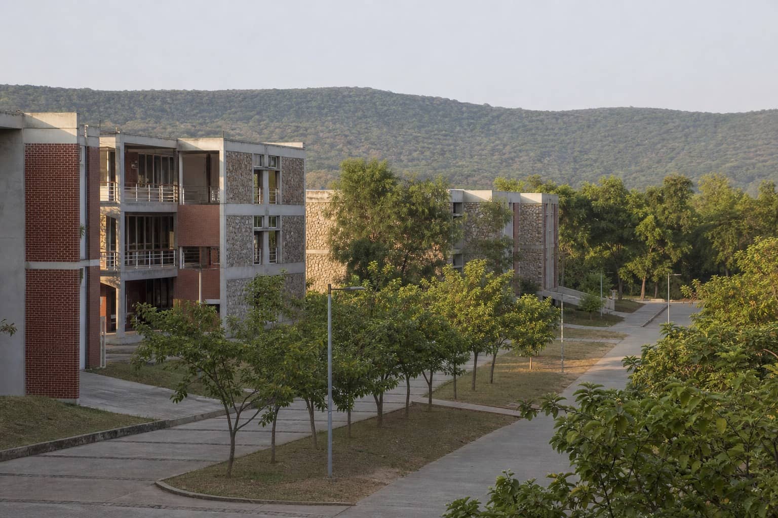Representational illustration of a modern Indian campus academic block and lawn under clear sky