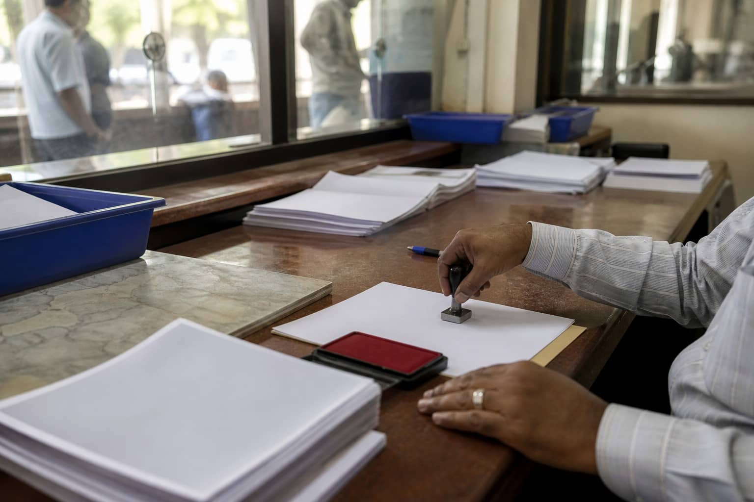 Illustrative municipal tax-counter desk with property-tax forms and a receipt stamp motif