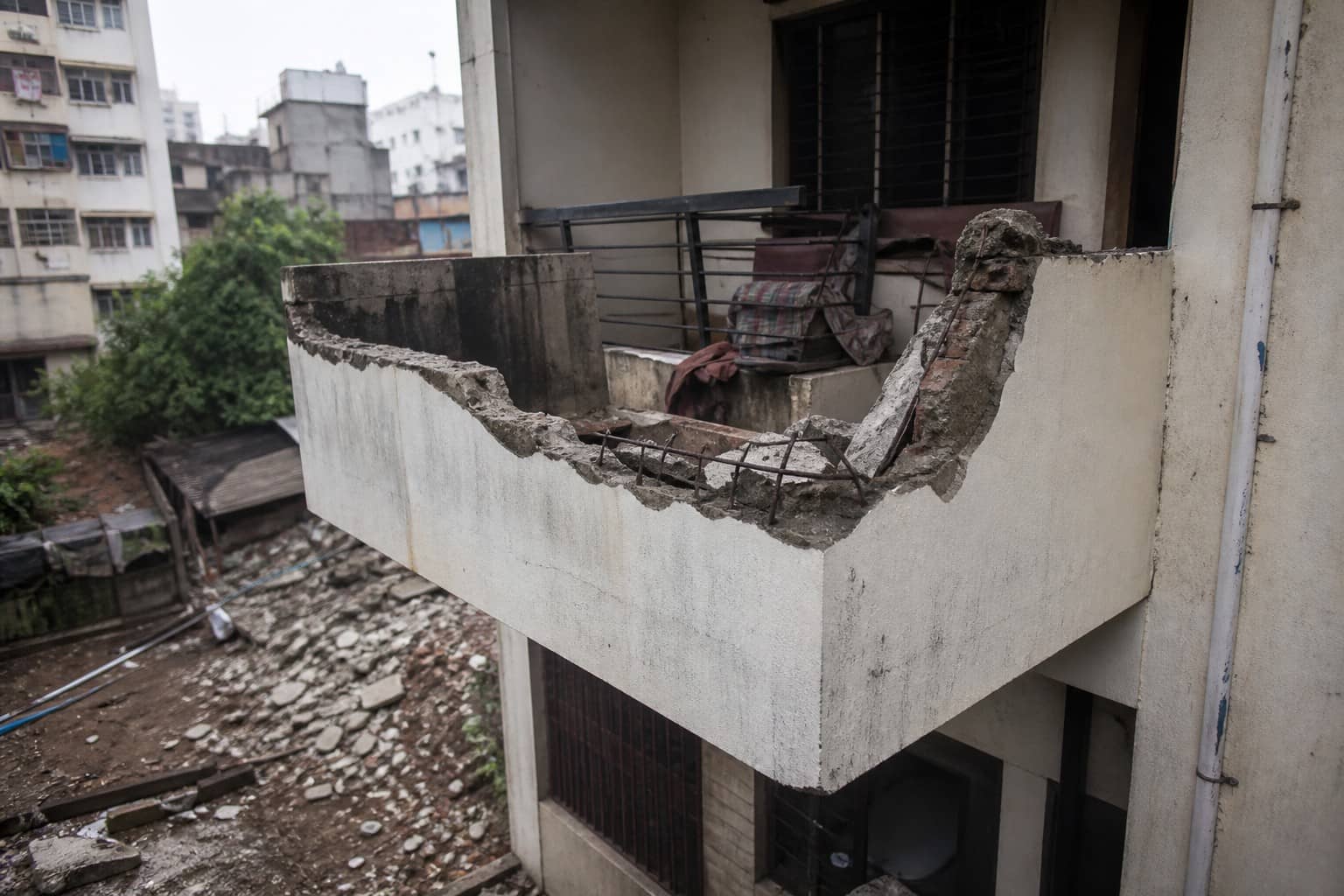 Illustrative damaged housing-block balcony silhouette with caution tape motif