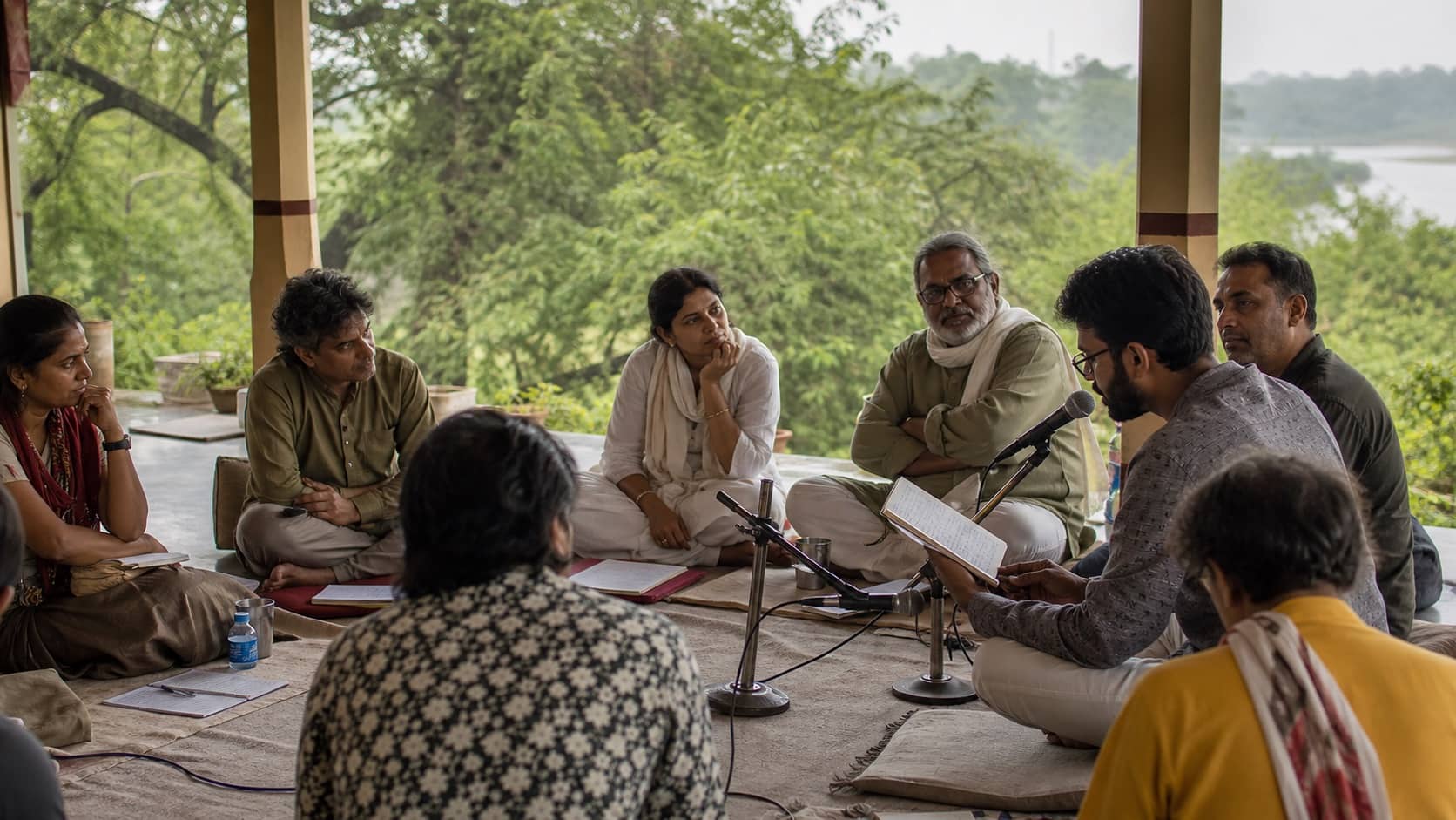 Poet reciting to a small audience during the monsoon