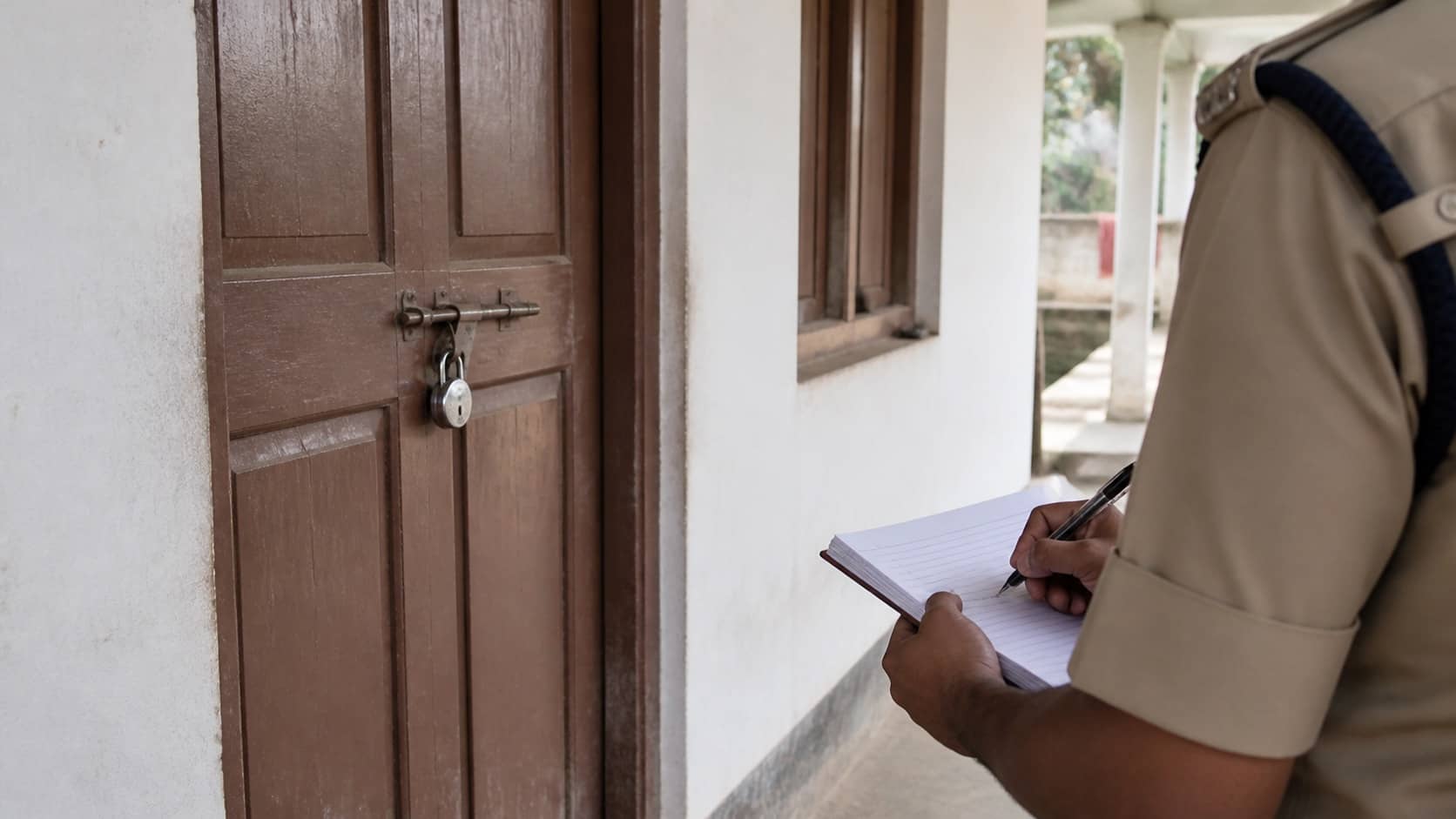 Police notebook and a closed residential door representing a family complaint