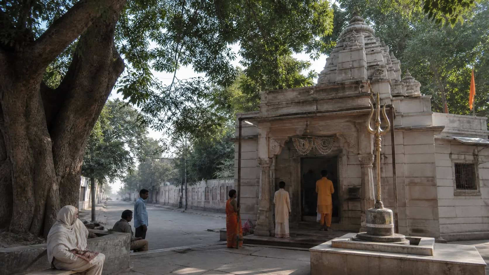 Small old Shiva shrine along a tree-lined Cantonment road in Varanasi