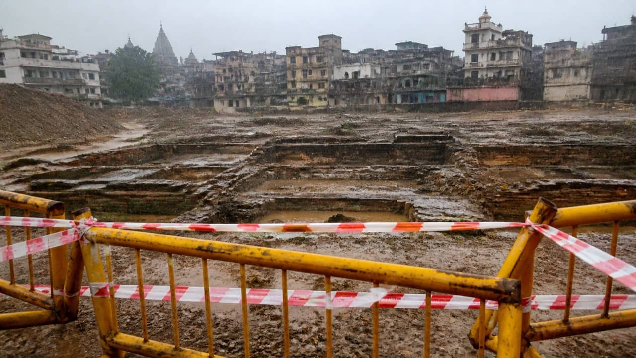 A barricaded rain-filled excavation on a vacant urban plot