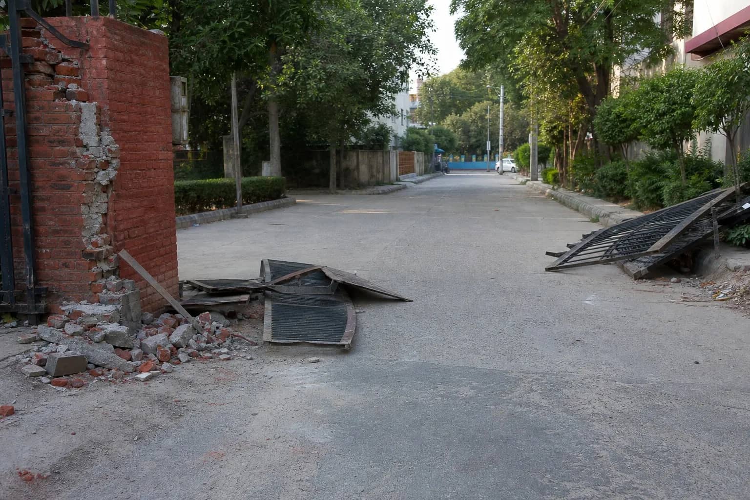 Broken masonry and an open internal colony road after a demolition drive
