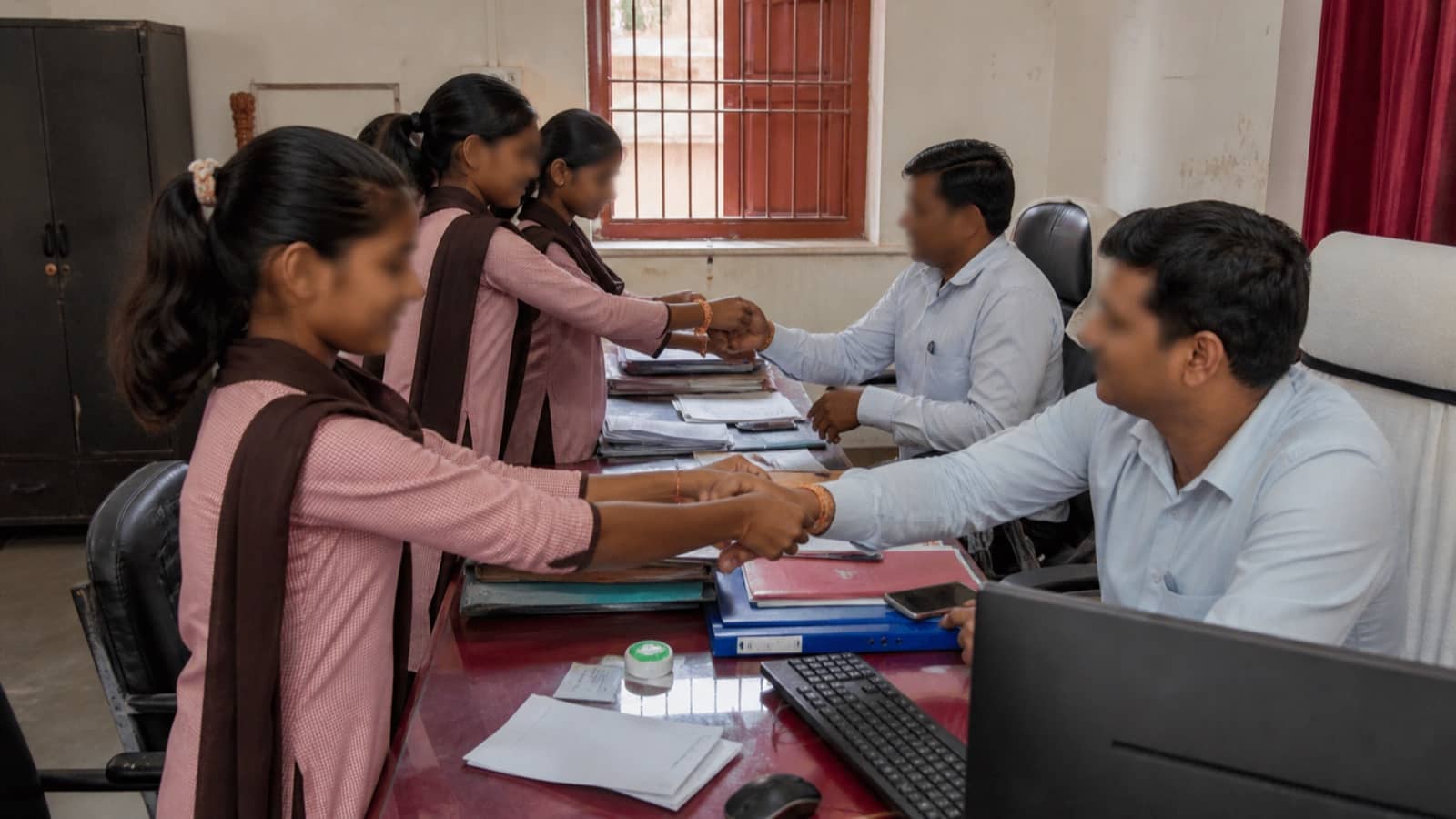 Schoolgirls tying rakhis to civic officials at a municipal office in Varanasi