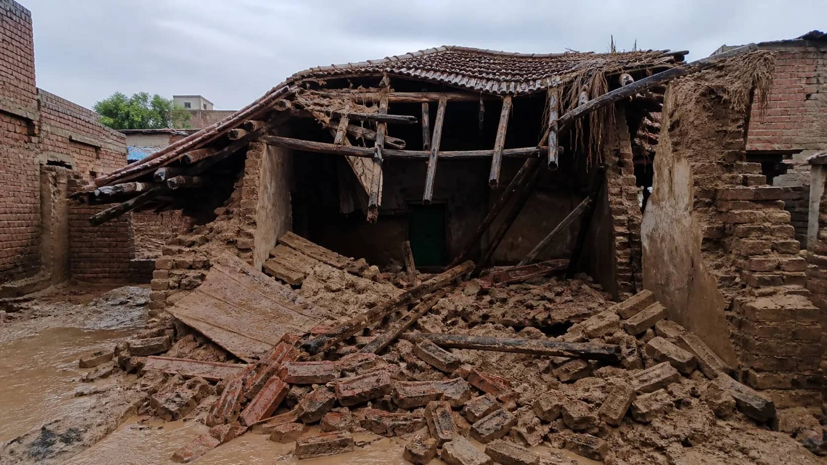 Collapsed mud-and-brick roof of an old rural house after monsoon rain