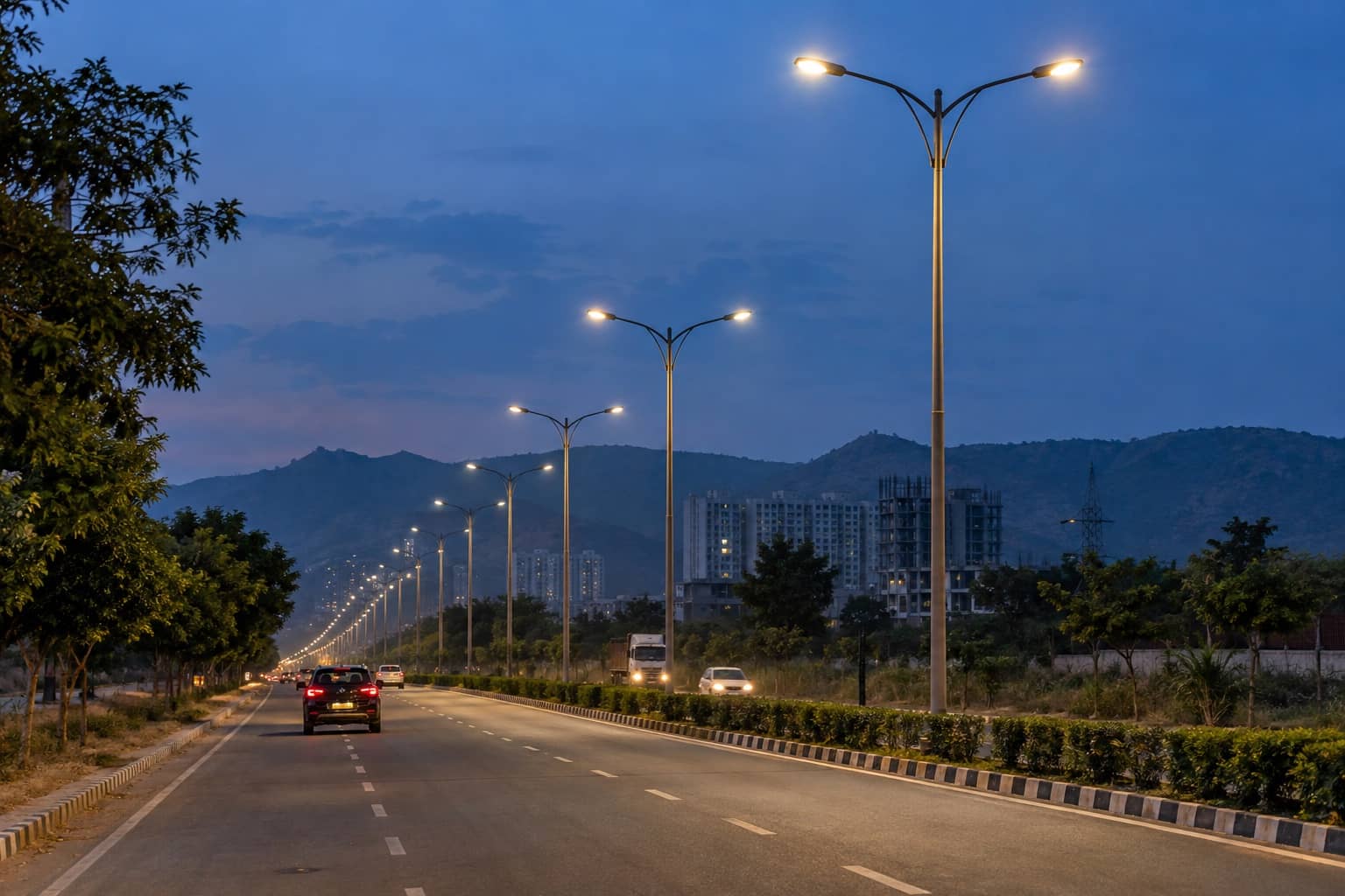 Streetlight poles along a main road in Sohna at dusk