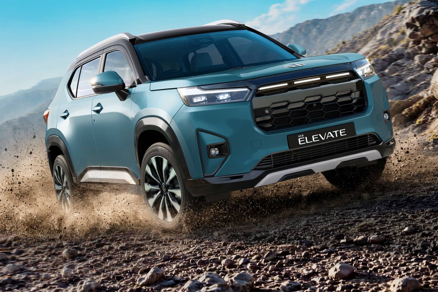 Teal Honda New Elevate SUV driving up a gravel mountain trail and kicking up dust