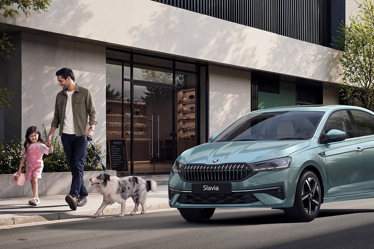 Blue-green Skoda Slavia sedan parked outside a modern building as a man, a young girl and a dog walk past