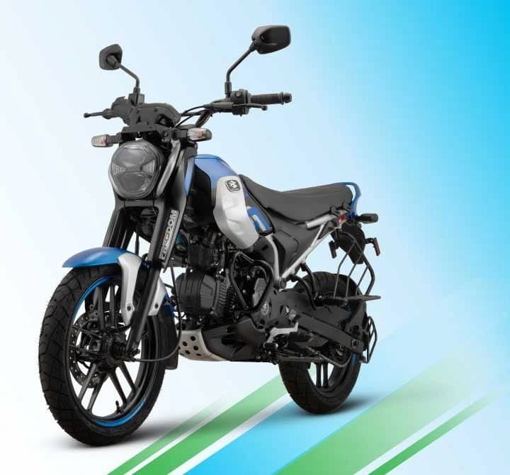 Blue, silver and black Bajaj Freedom 125 CNG motorcycle, front three-quarter view against a light blue background with green stripes