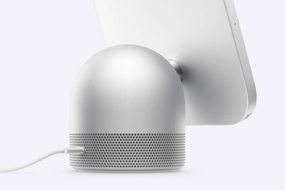 Rear view of a silver Apple HomeView with its domed speaker base and connected USB-C cable.