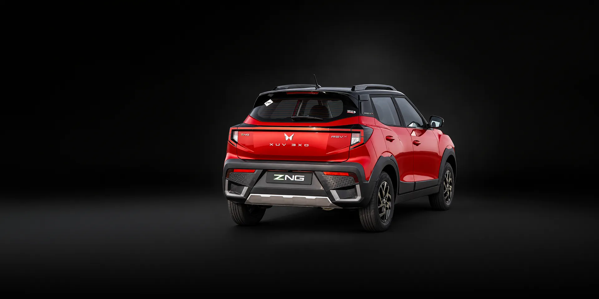 Red Mahindra XUV 3XO ZNG, rear three-quarter view.