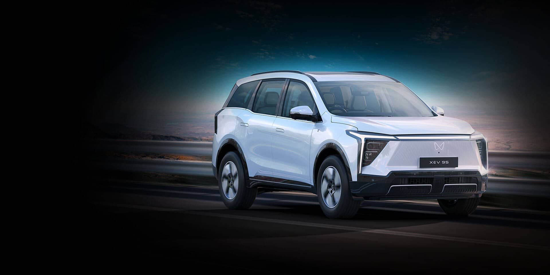White Mahindra XEV 9S electric SUV against a dark backdrop