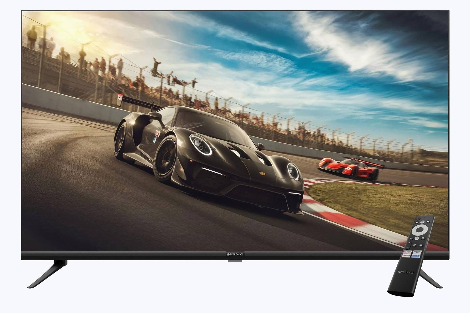 A black Zebronics TV with a remote, showing a sports car on a race track